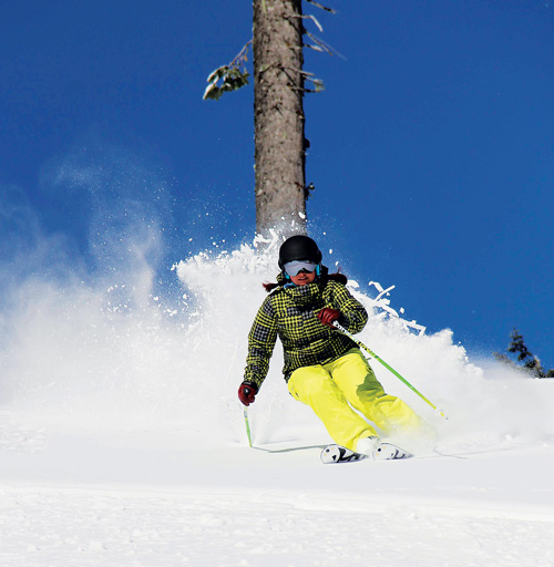 Skier shredding turns on a sunny day at 49 Degrees North.