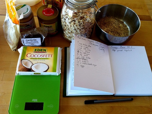 Baking ingredients and recipe book on a kitchen table.
