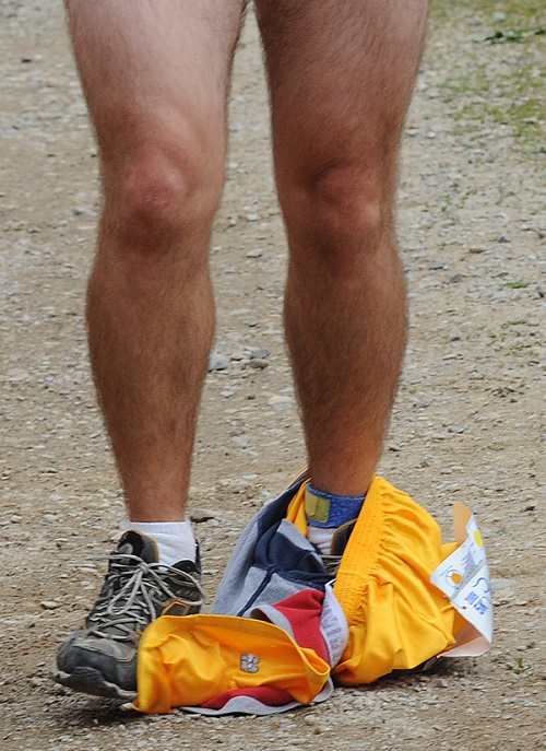 Male runner's legs with socks and shoes, and set of shorts dropped around his ankles.