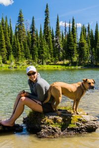 Hiker and her best friend taking a break at Ten Lakes Scenic Area. Photo: Aaron Theisen