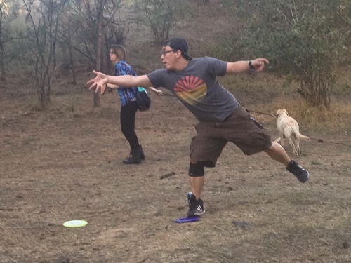 Joe tosses the disk while Kate looks on and Dexter the dog runs for the next hole. Photo: Bea Lackoff