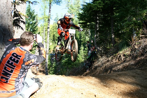 Mountain biker getting air on a jump on a dirt trail at Silver Mountain Bike Park in Kellogg, Idaho.