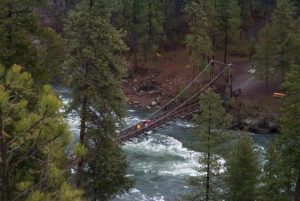 Swinging bridge over the Spokane River and its raging whitewater rapids at the Bowl and Pitcher area of Riverside State Park.