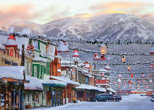 Storefront and downtown street in Whitefish, Montana, adorned with festive Christmas lights and decor.