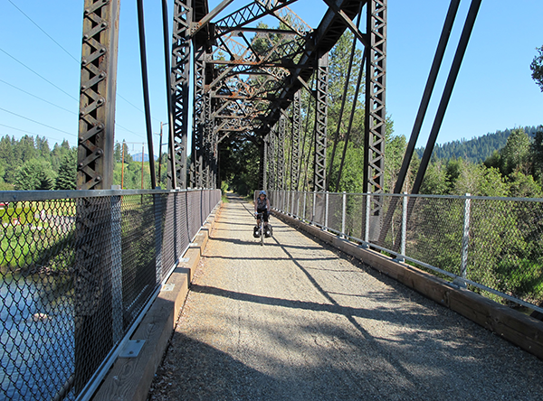 Biker crossing a bridge along the Palouse to Cascades Trail, formerly called the John Wayne Pioneer Trail. Photo by Marilyn Hedges.