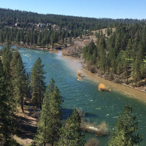 Aerial view of the Spokane River downriver of downtown Spokane -- with forested areas alongside the river.