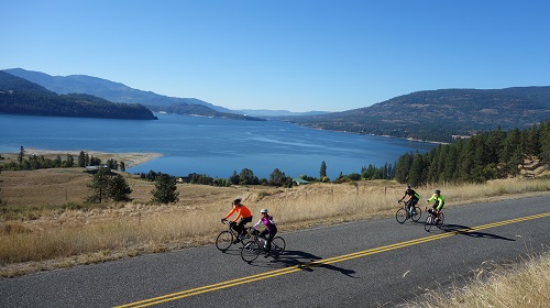 Cyclists riding alongside a rural road in Colville, Washington.