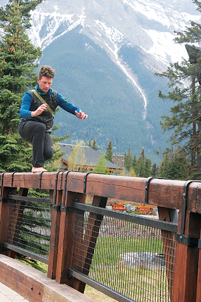 Photo of a guy balancing on a bridge rail by Katie Botkin.