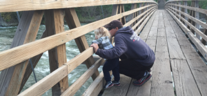 Photo of father and son on wooden bridge over the Spokane River.