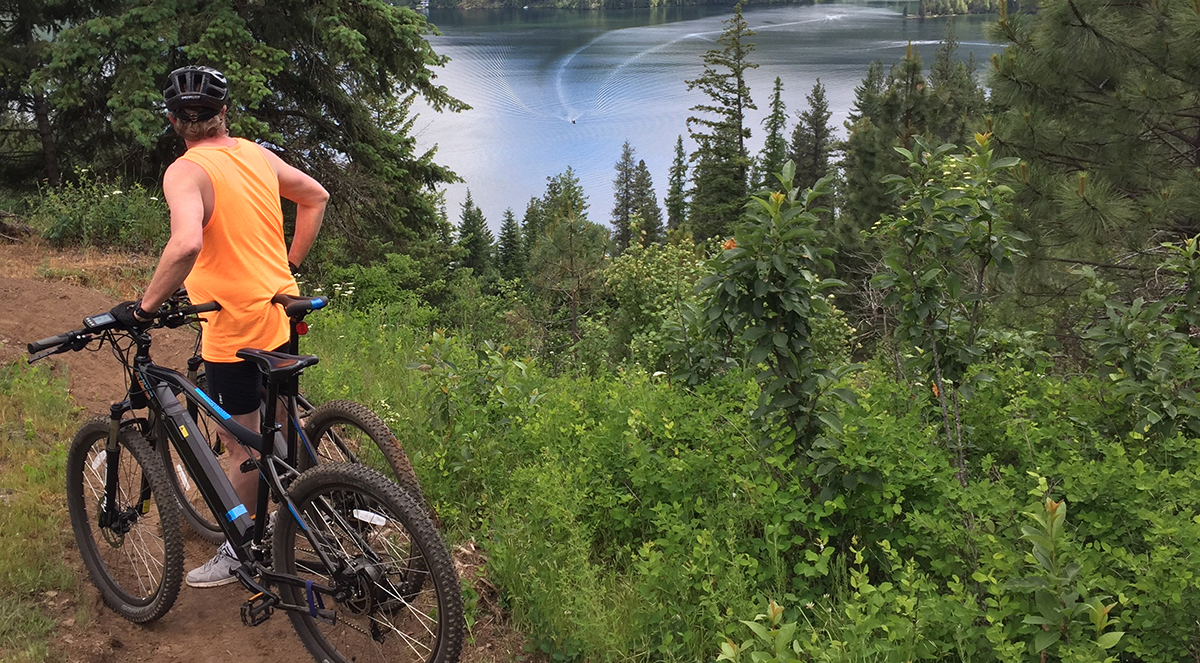 Photo of e-bike rider on side of trail admiring the view.
