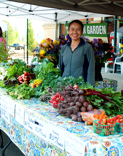 Photo of vendor with fruit and vegetables for offer.