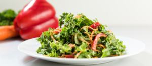 Photo of nutty kale slaw arranged with carrots and bell peppers.