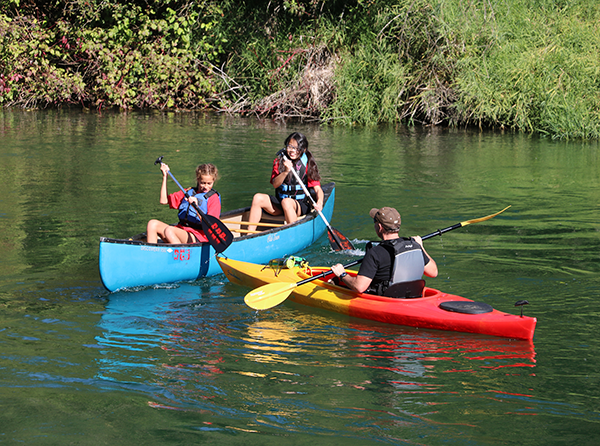 Photo of kids kayaking on a sunny day.