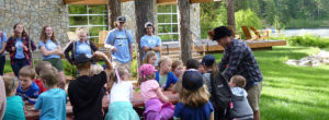 Camp Spalding summer staff teaching campers about wildlife as they touch animal pelts before going on a hike.