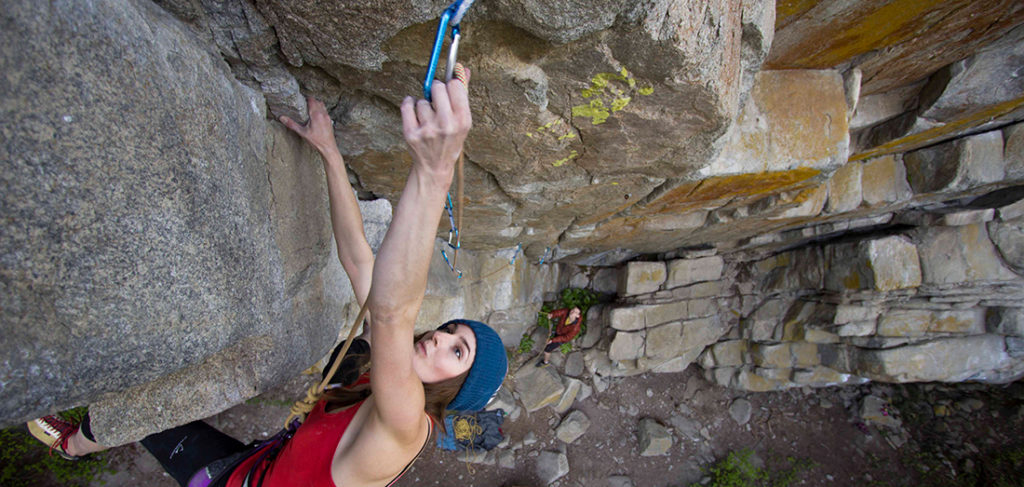 Photo of climber clipping on a lead route in Pack Rat Cave.