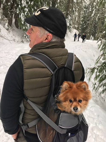 Photo of Glen Copus hiking with his dog Phoebe in a backpack pack.