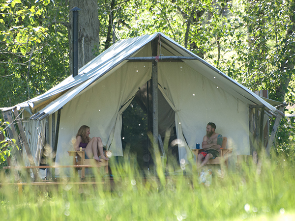 Photo of campers outside of large tent.