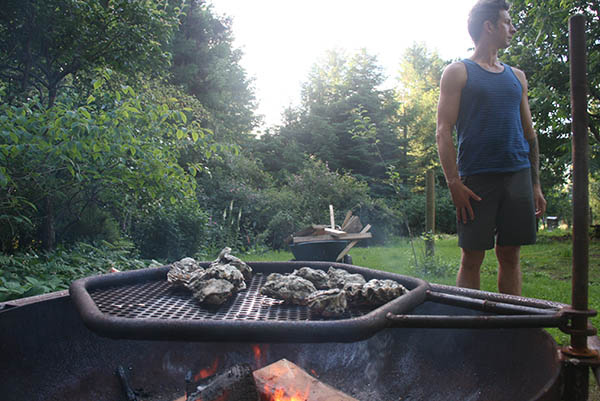 Photo of firepit with man standing in the background.