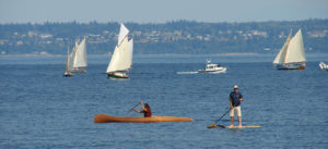 Photo of Hari Heath in his paddlecraft with boats in the background in Port Townsend Bay.