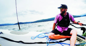Photo of Jacob Rothrock reclining on a sailcraft on Lake Coeur d'Alene.