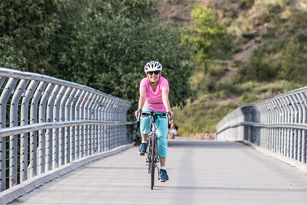 Photo of Lisa Brown biking across bridge.