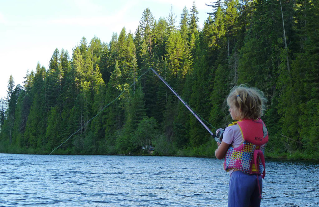 Photo of girl fishing at Priest while standing on a log.