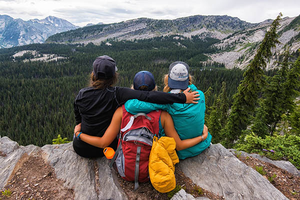 Photo of three hikers sitting on ledge overlooking Engle Lake.