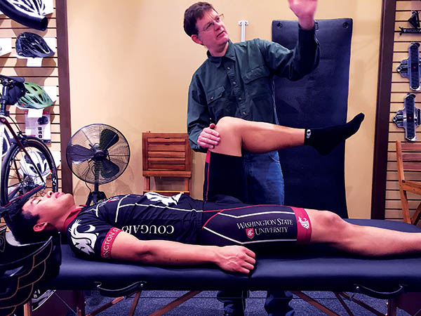 Photo of customer lying on a fully reclined chair while Brice checks range of motion.