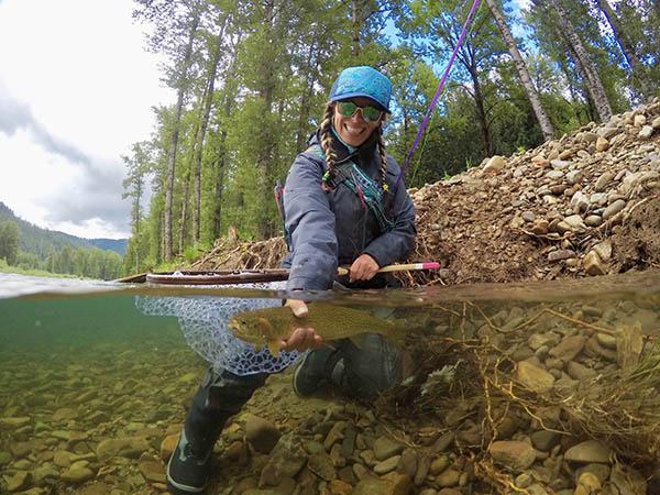 Photo of angler holding fish in the river.