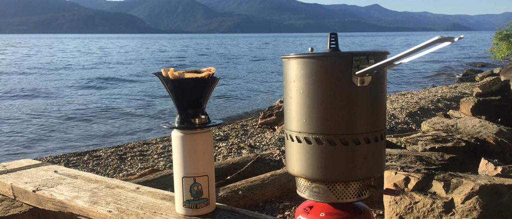 Photo of backpacking stove with pot and coffee on the shore of Pend Orielle.