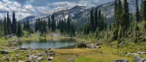 Photo of alpine lake with mountain peak in the background.