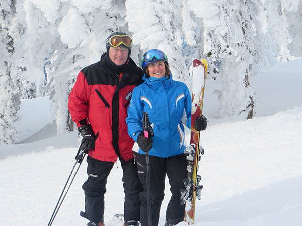 Photo of Seth & Gloria Fletcher posed on ski slope with gear.