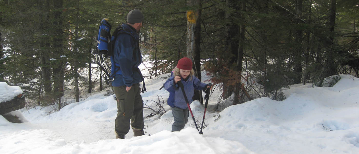 Photo of dad and son snowshoeing together.