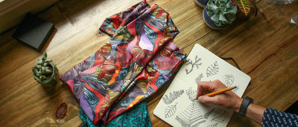 Photo of leggings on workbench along next to product sketch.
