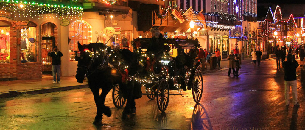 Photo of carriage down the main street of Leavenworth with lighted shops.
