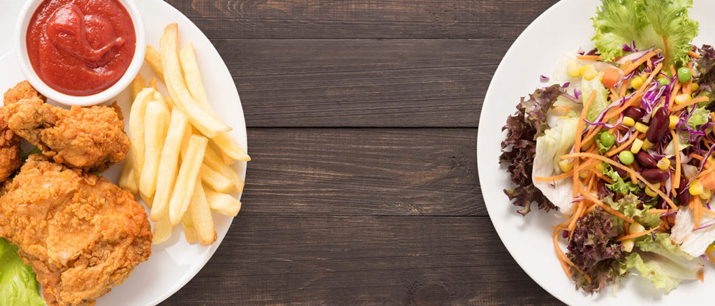 Photo of plate of chicken and fries versus plate of salad.
