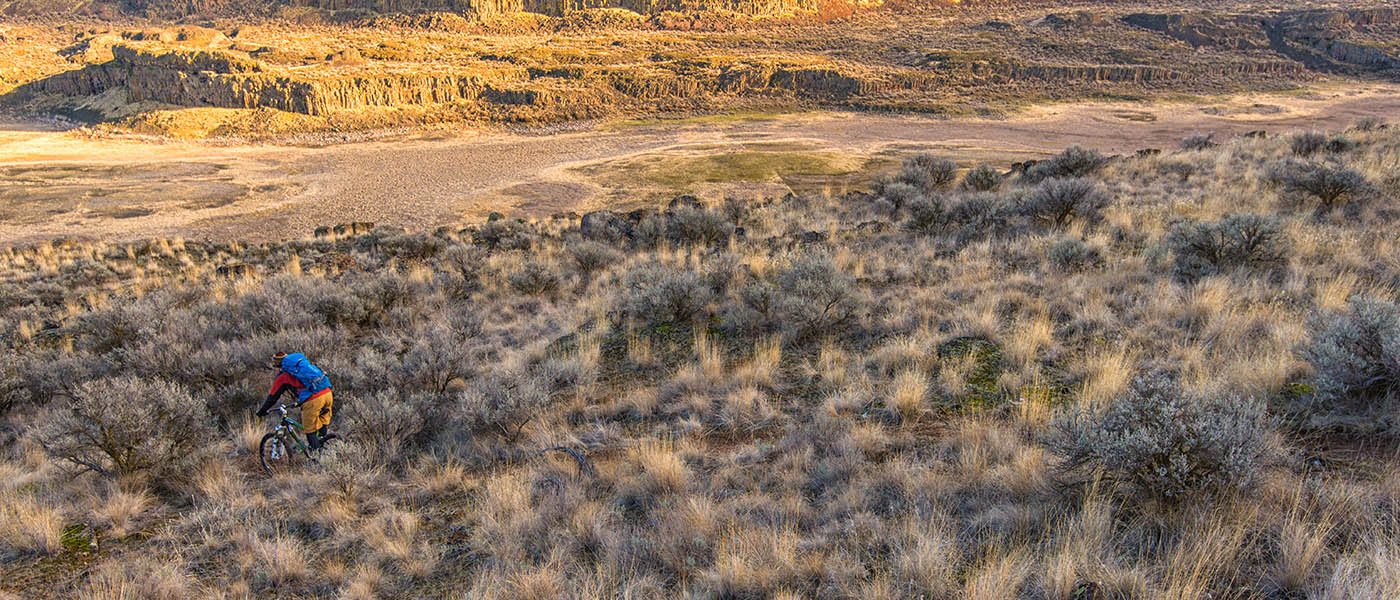 Photo of mountain biker riding through the Scablands taken from above.