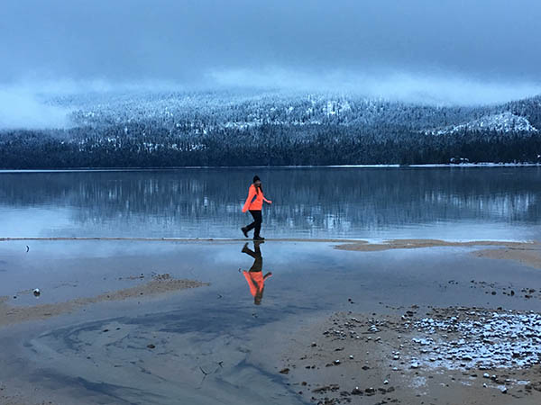 Photo of girl running across Priest Lake.