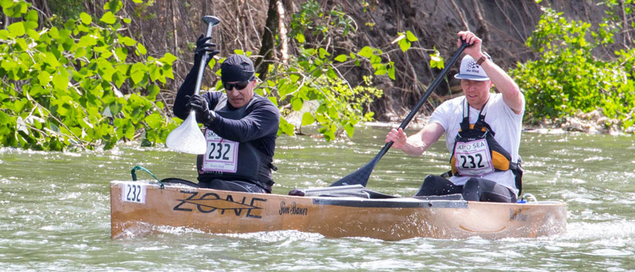 Photo of two men paddling a canoe