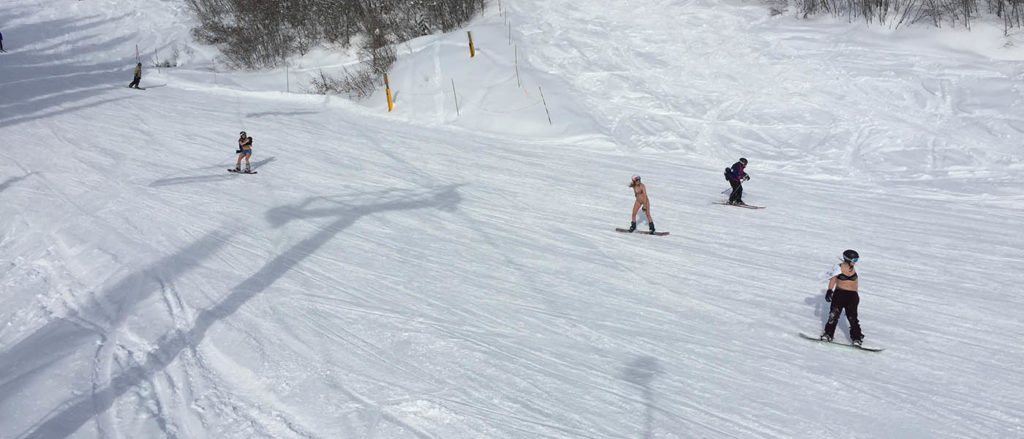 Photo of skiers wearing swimwear on the slopes.