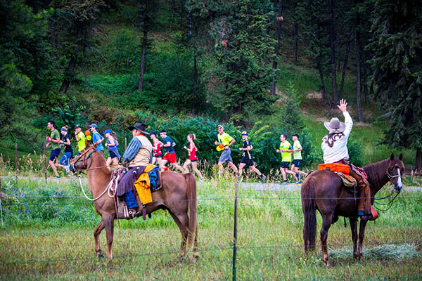 Photo of volunteers on horseback cheering on runners.