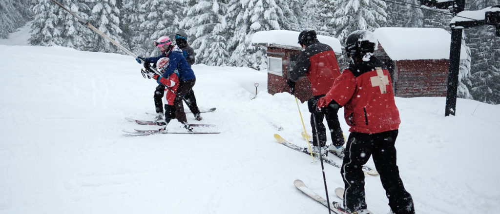 Photo of skiers and ski patrol on rope tow.