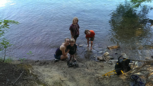 Children cooling off in Sullivan Lake with feet in the water.