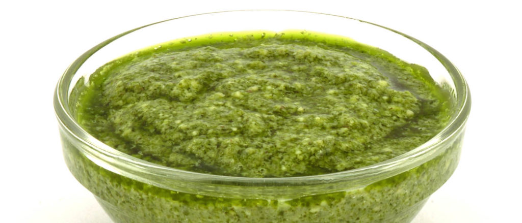 Photo of wild greens pesto in glass dipping bowl.