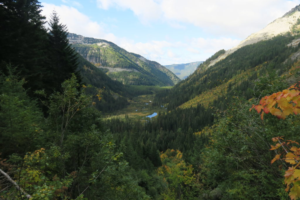 Slopes of the Cabinet Mountains in western Montana, with a view of an alpine lake and trees.