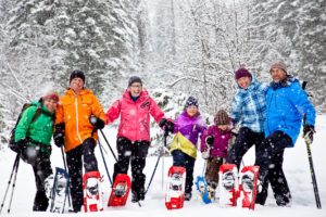 Three generations of a family snowshoeing together in Fernie, British Columbia.