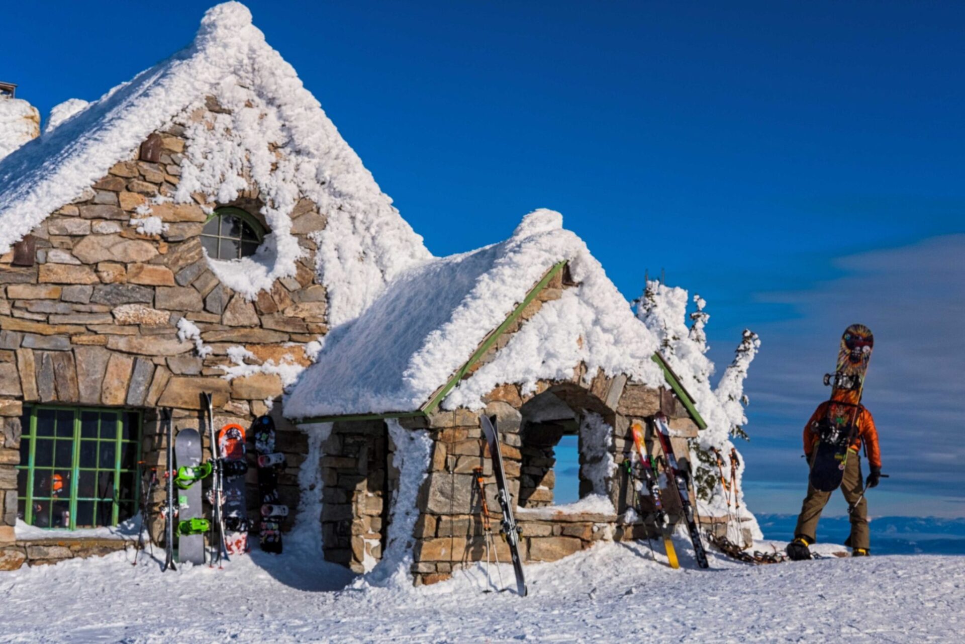 Person walking up to a snow covered house.