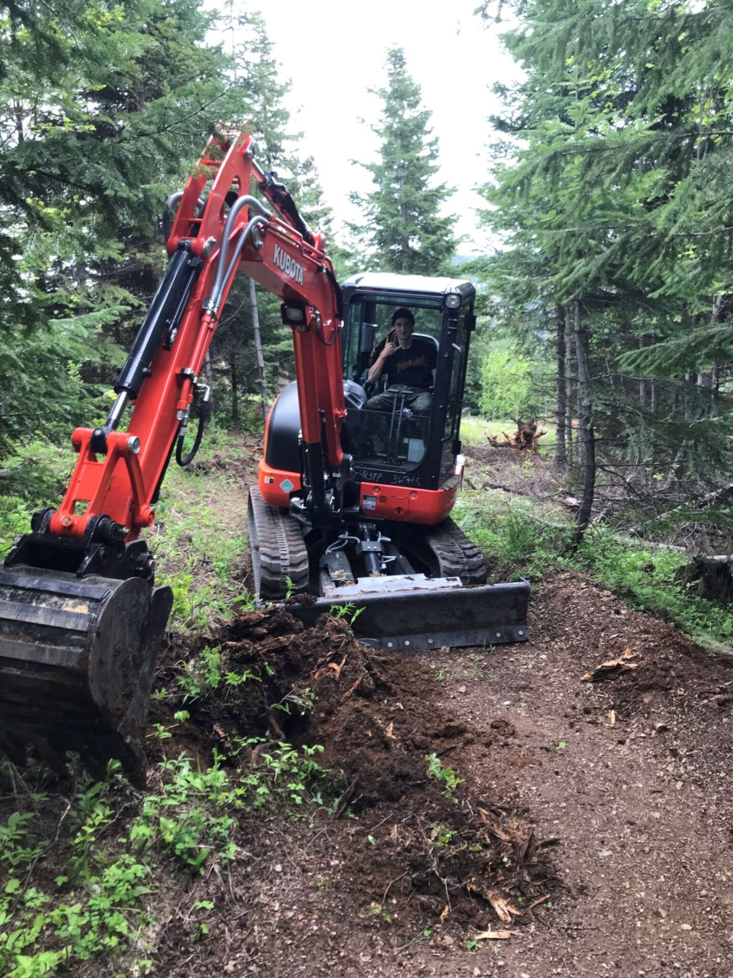 A person in a construction machine, clearing a trail.