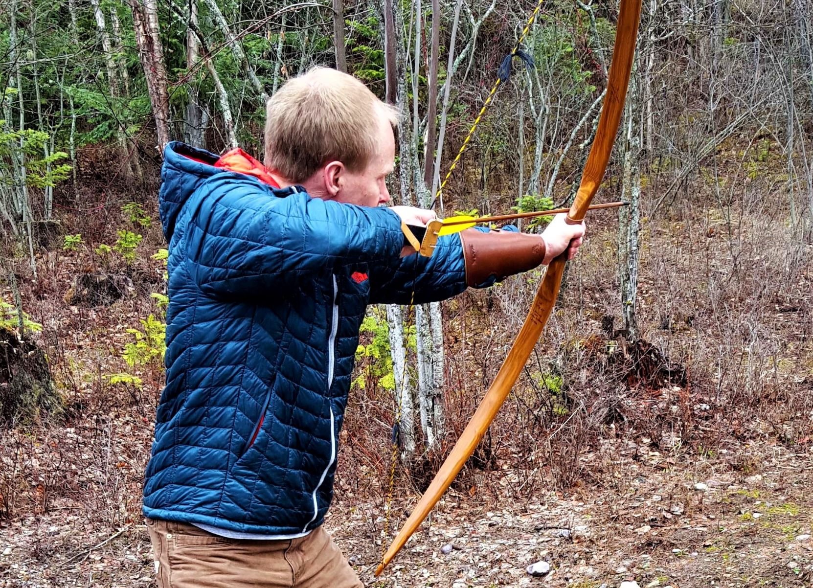 A man shooting a long bow and arrow.