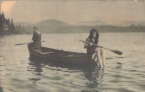 A old black and white vintage photo of two women canoeing.